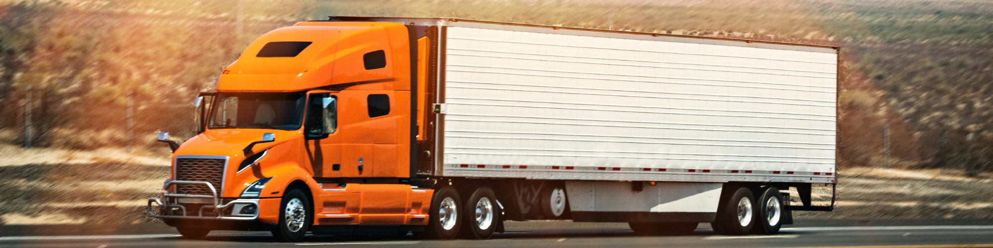 Image of a tractor trailer traveling west on the highway